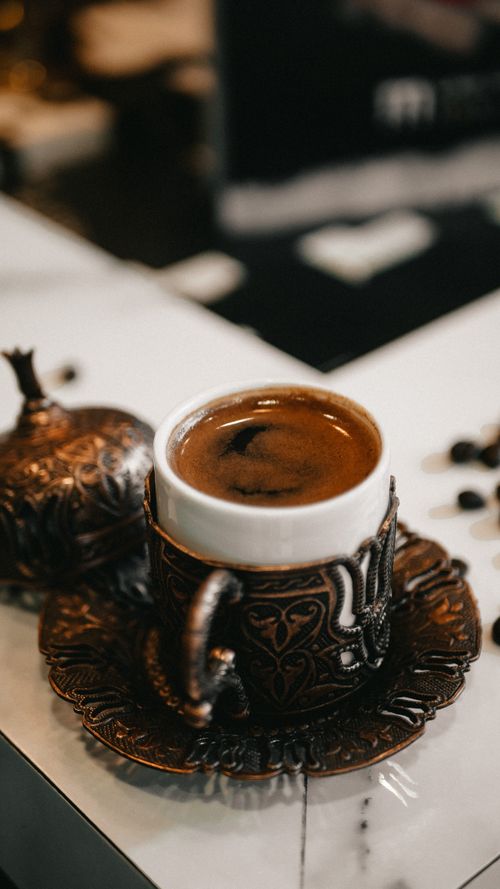 Free An ornate cup of espresso on a table, showcasing intricate design and rich color. Stock Photo