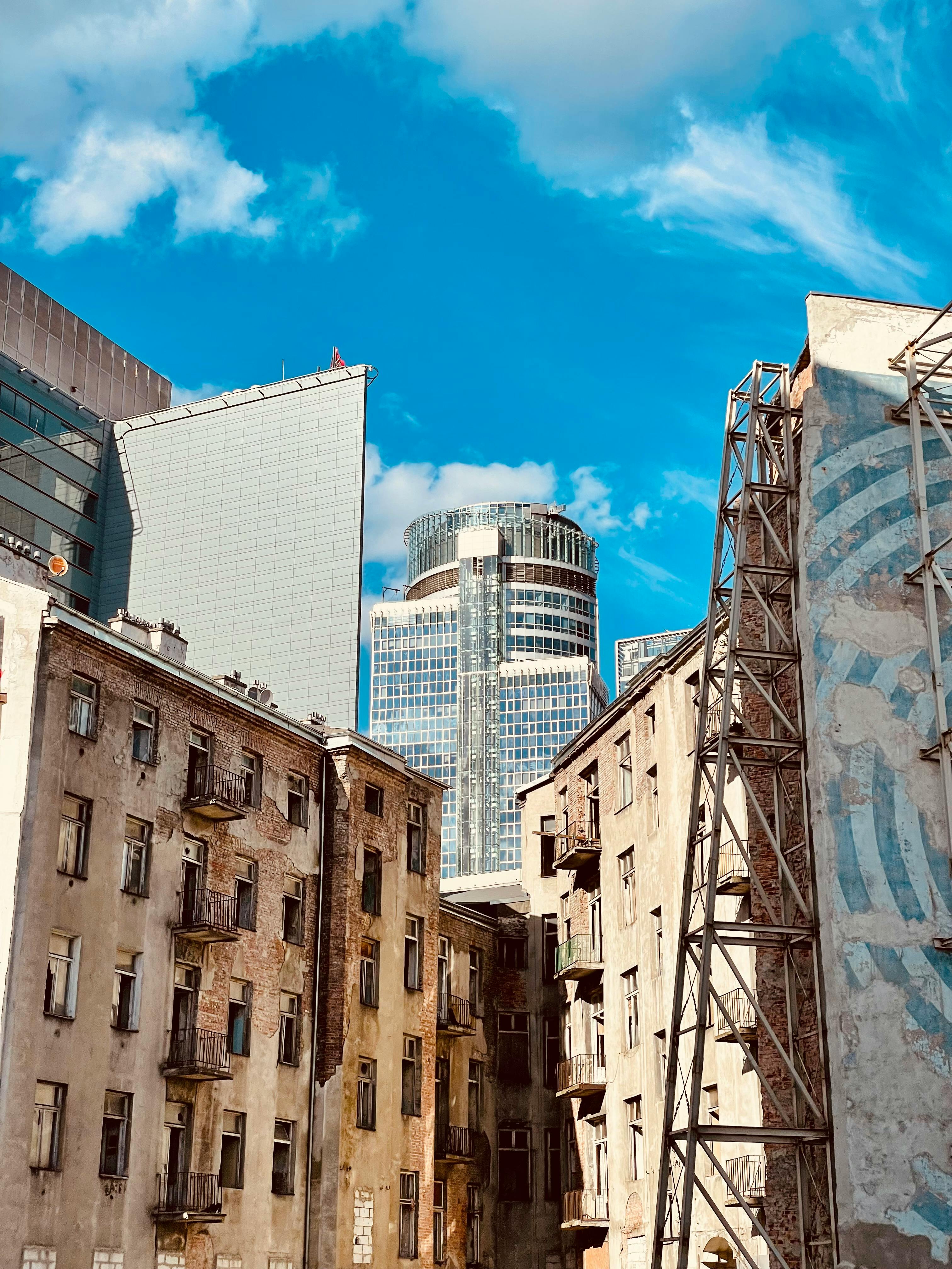 old tenement houses on the background of a modern skyscraper of uniqa axa insurance company at panska street warsaw