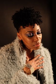 Stylish portrait of a woman with curly hair, wearing a fur coat and bracelet in Boston.