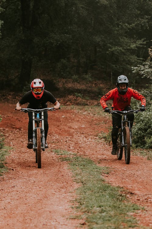 Two People Biking on a Dirt Road