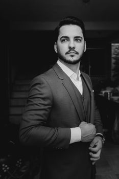 Stylish portrait of a confident man in a suit, captured in grayscale.