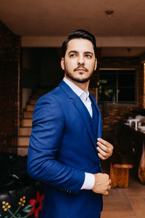 Free Portrait of a confident man in a blue suit, standing indoors with natural light. Stock Photo