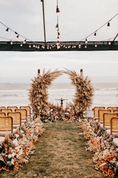 Beautiful beachfront wedding setup with floral arrangements and warm lighting.