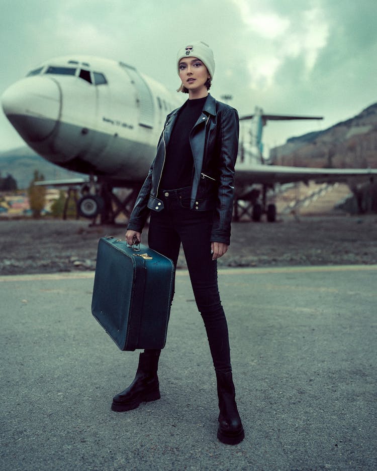 A Woman Carrying A Suitcase