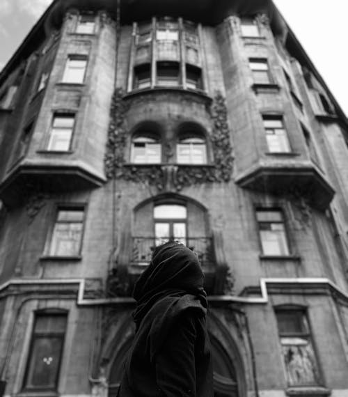 Free Grayscale Photo of a Person Beside a Building Stock Photo