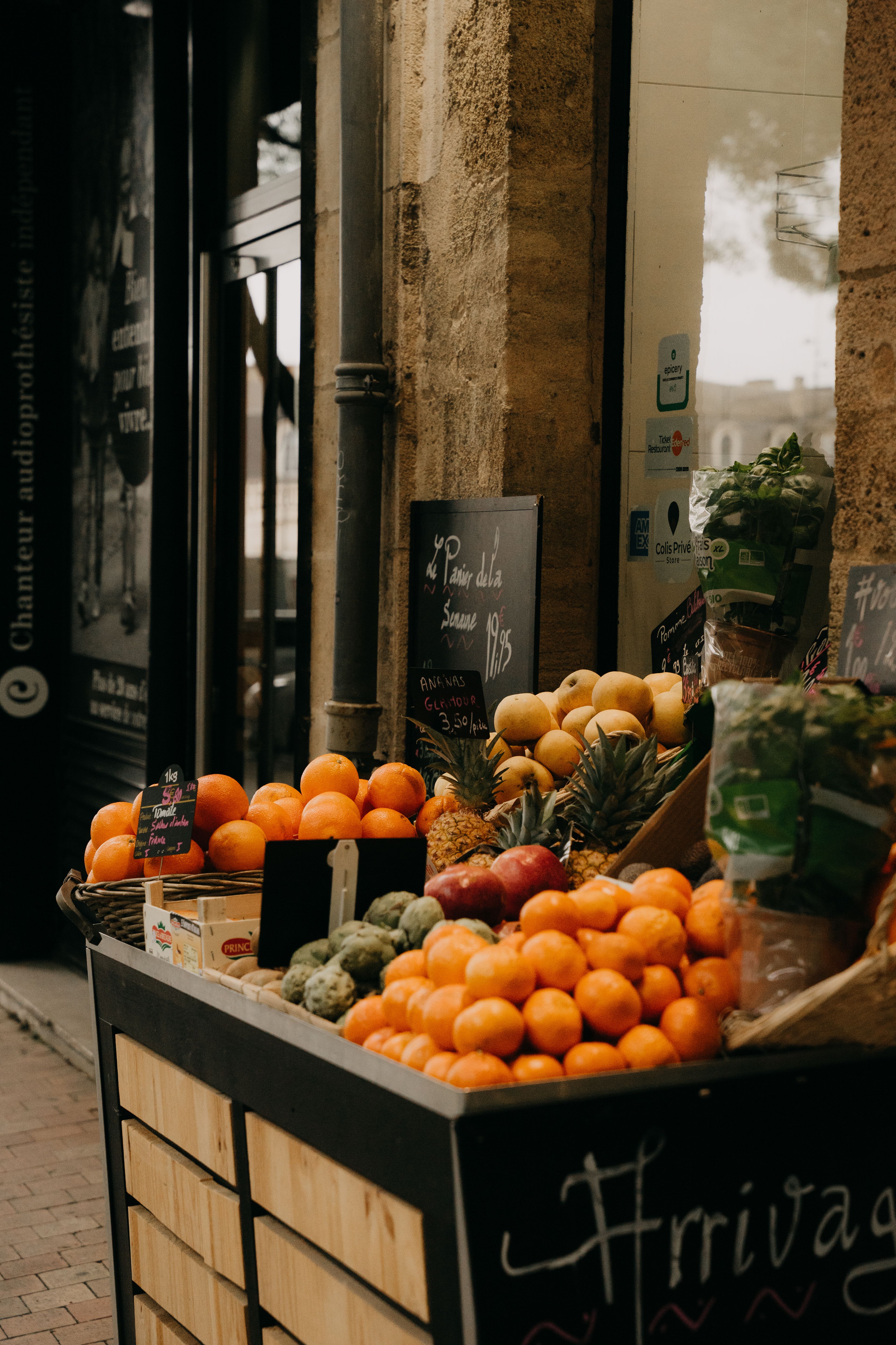 Étal de fruits et légumes frais installé sur un trottoir commerçant