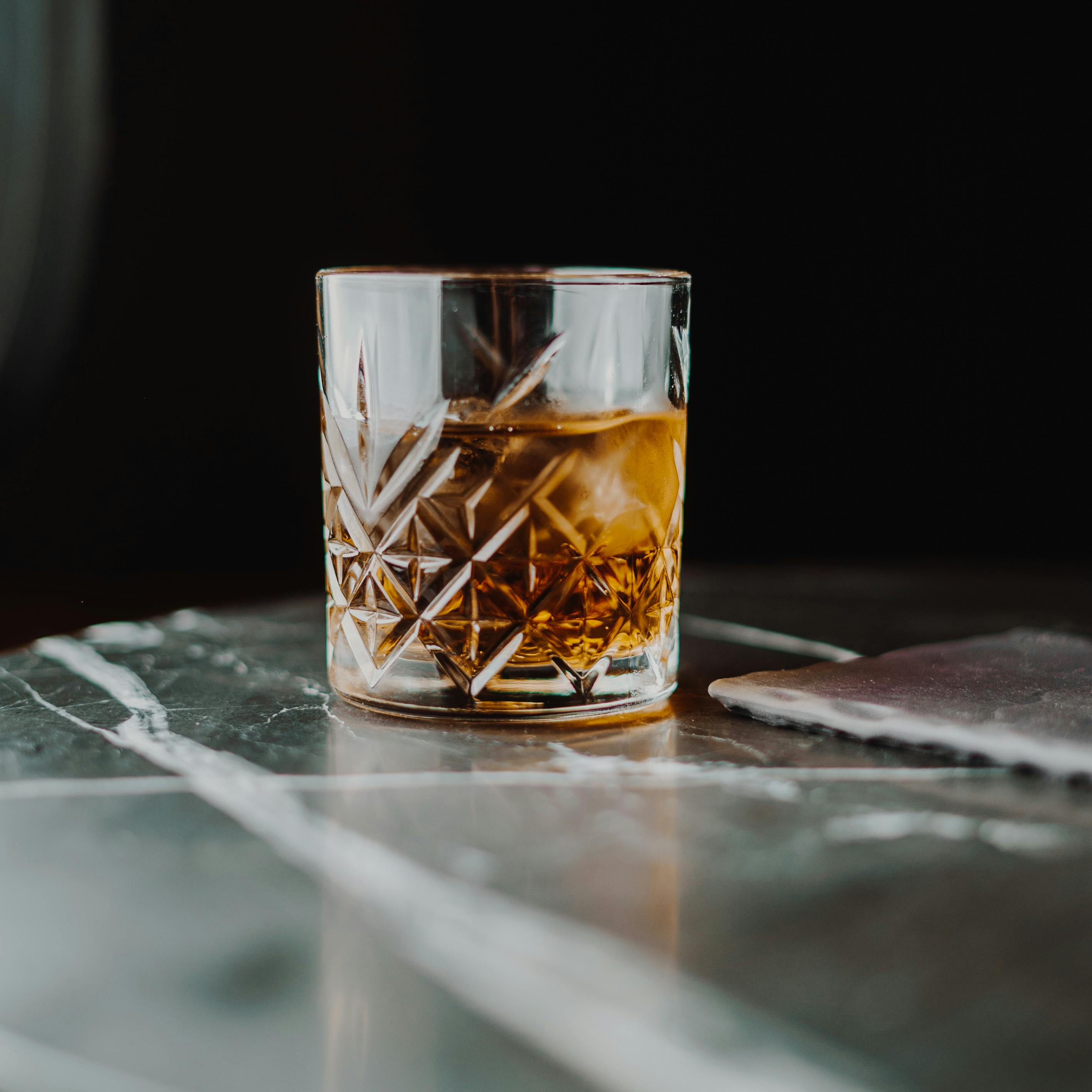 Closeup Photo of Liquor Bottle Against Black Background · Free Stock Photo