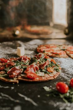 Delicious gourmet pizza topped with fresh ingredients, captured in a rustic kitchen setting.