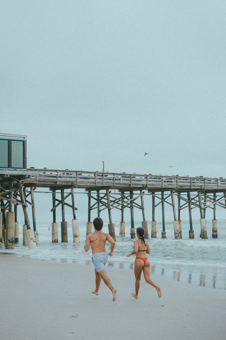 Couple Running On Beach Shore