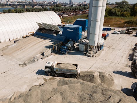 An aerial view of an active construction site with trucks and machinery in Novosibirsk, Russia.