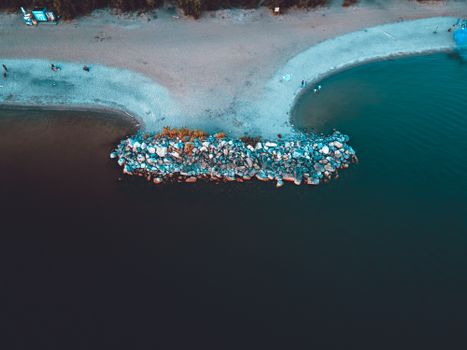 Drone capture of a coastline with rocks jutting into the water in Novosibirsk, Russia.