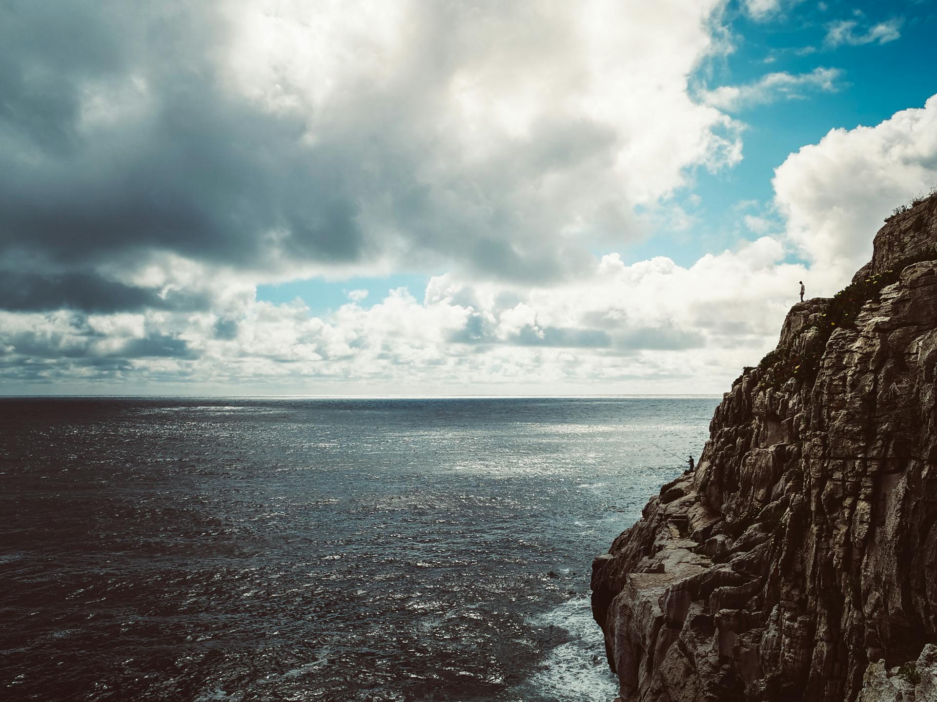 Majestic cliffs in Portugal with ocean view and dramatic cloudy sky, perfect for travel inspiration.