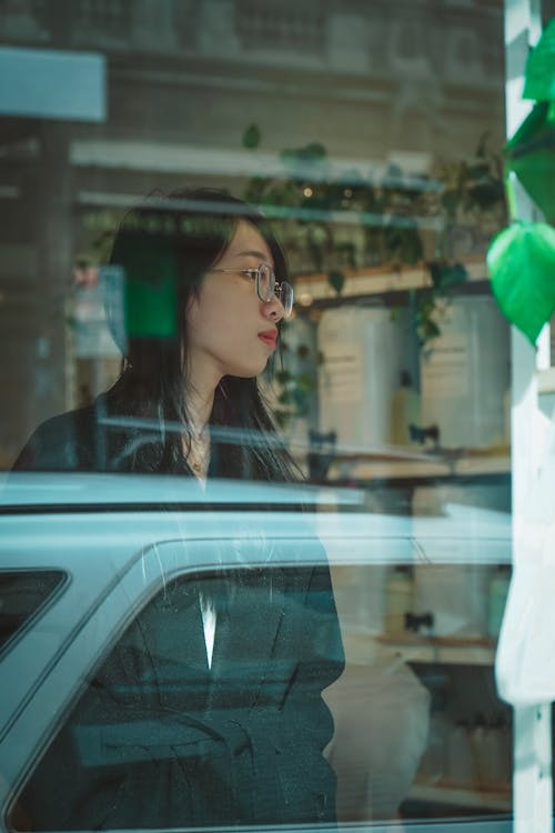 Free Woman in Black Coat Standing Beside Glass Window Stock Photo