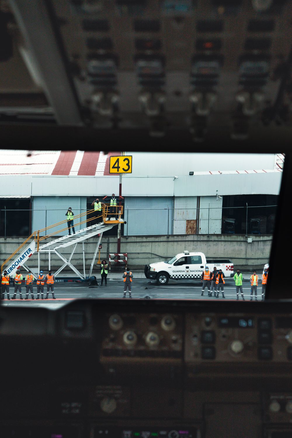 Ground crew preparing for aircraft maintenance at airport, view from cockpit