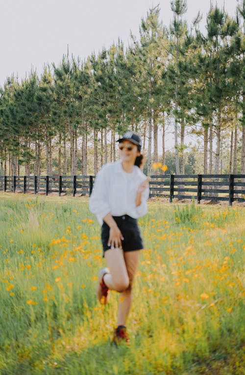 Free Woman in White Long Sleeve Shirt and Black Skirt Standing on Green Grass Field Stock Photo
