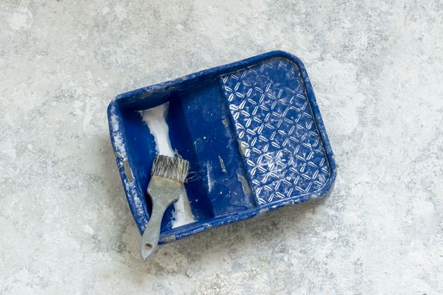 Farbschale mit blauer Farbe und Pinsel