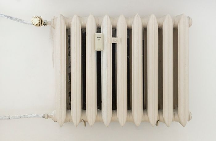 Weißer Heizkörper an einer hellen Wand