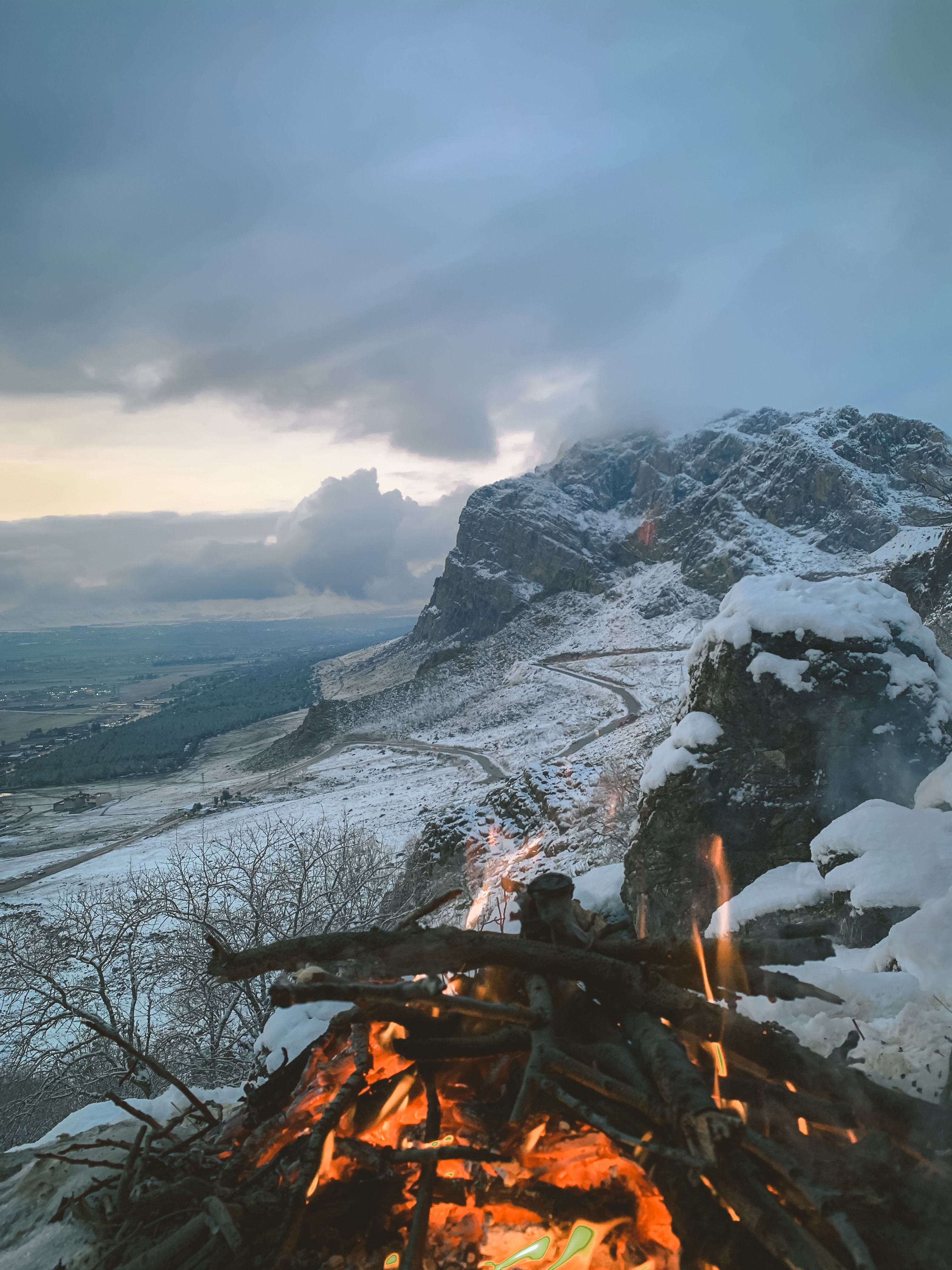 Bonfire near Snow-Covered Mountain under the Cloudy Sky · Free Stock Photo