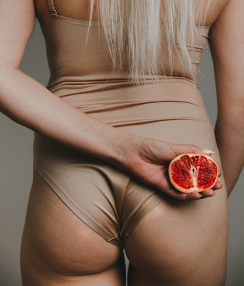 Back of Woman in Bodysuit Holding a Red Orange