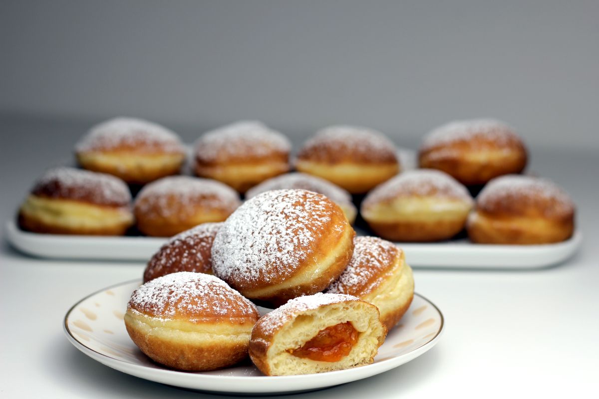 Filled doughnuts dusted with sugar, close up.