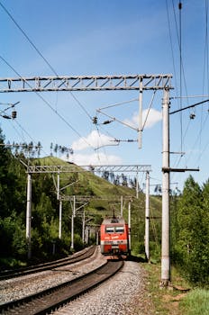 A train travels through lush green hills, showcasing beautiful natural scenery.
