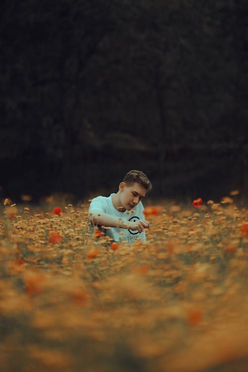 Teenage Boy Sitting on a Flower Field