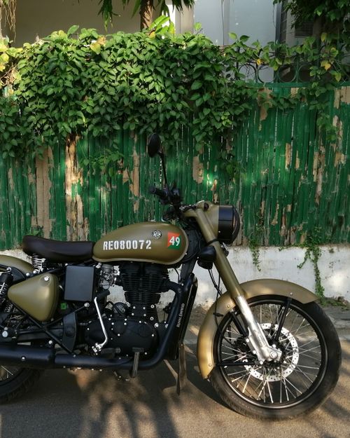 Free Side view of a classic Royal Enfield motorcycle parked on a sunny day. Stock Photo