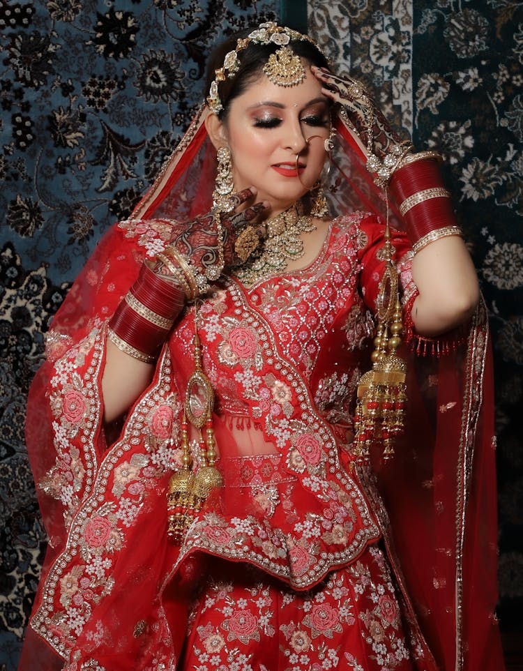 An Elegant Woman In Red And Gold Saree