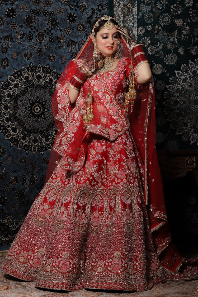 An Elegant Woman In Red And Gold Saree