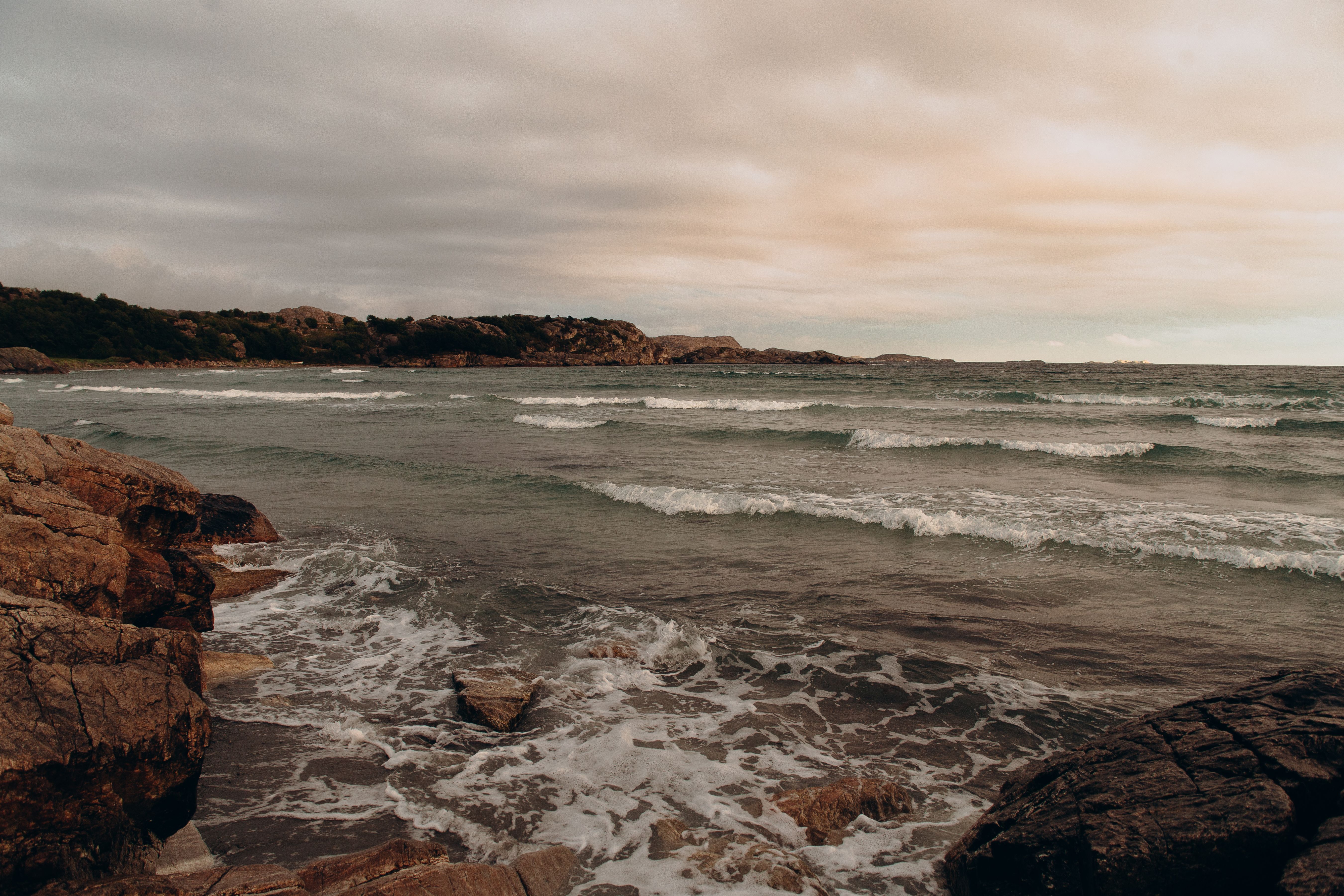 Ocean Waves Crashing on Rocks Under Cloudy Sky · Free Stock Photo