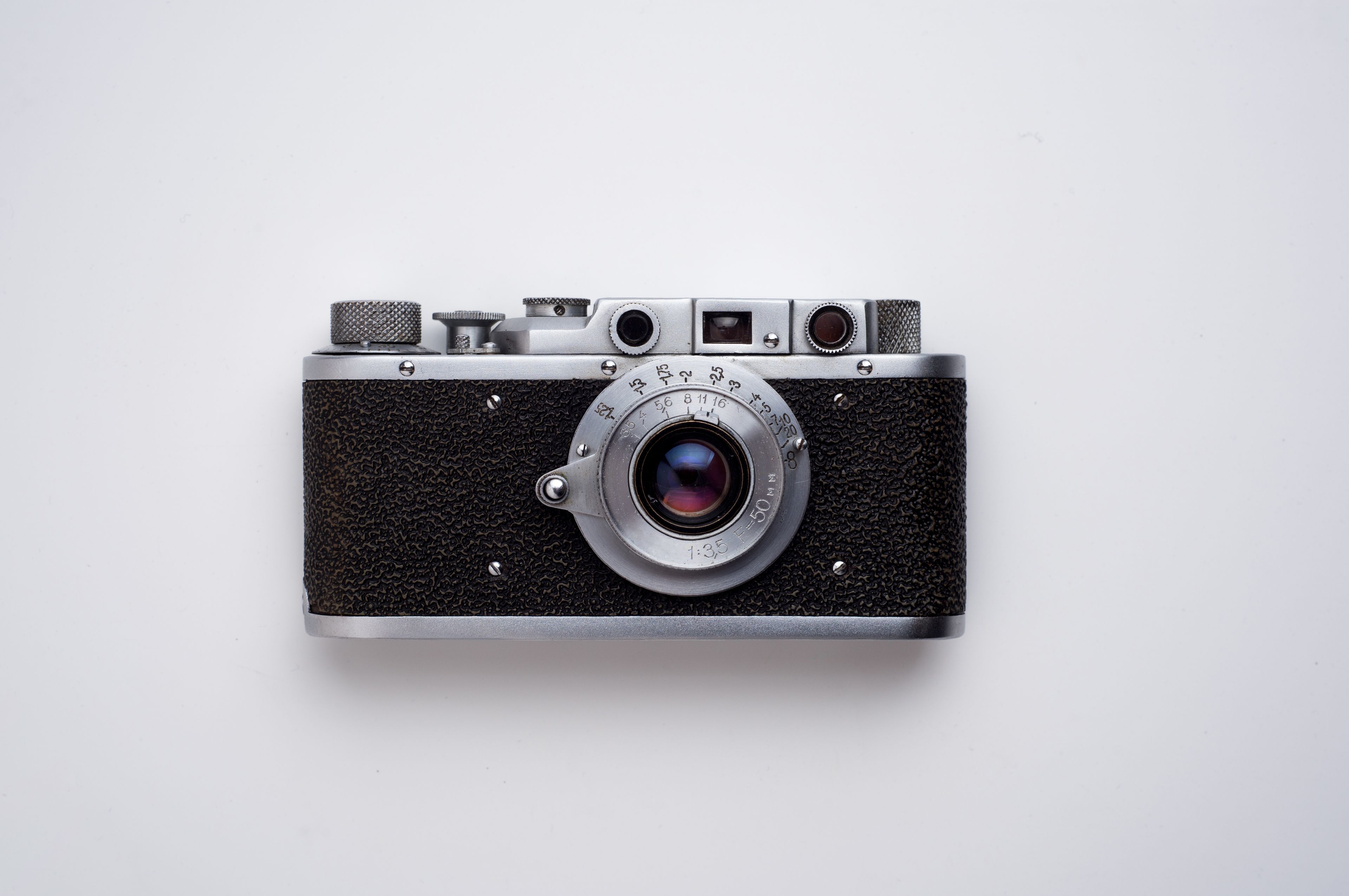 The old camera and a scatter of prints on the map table