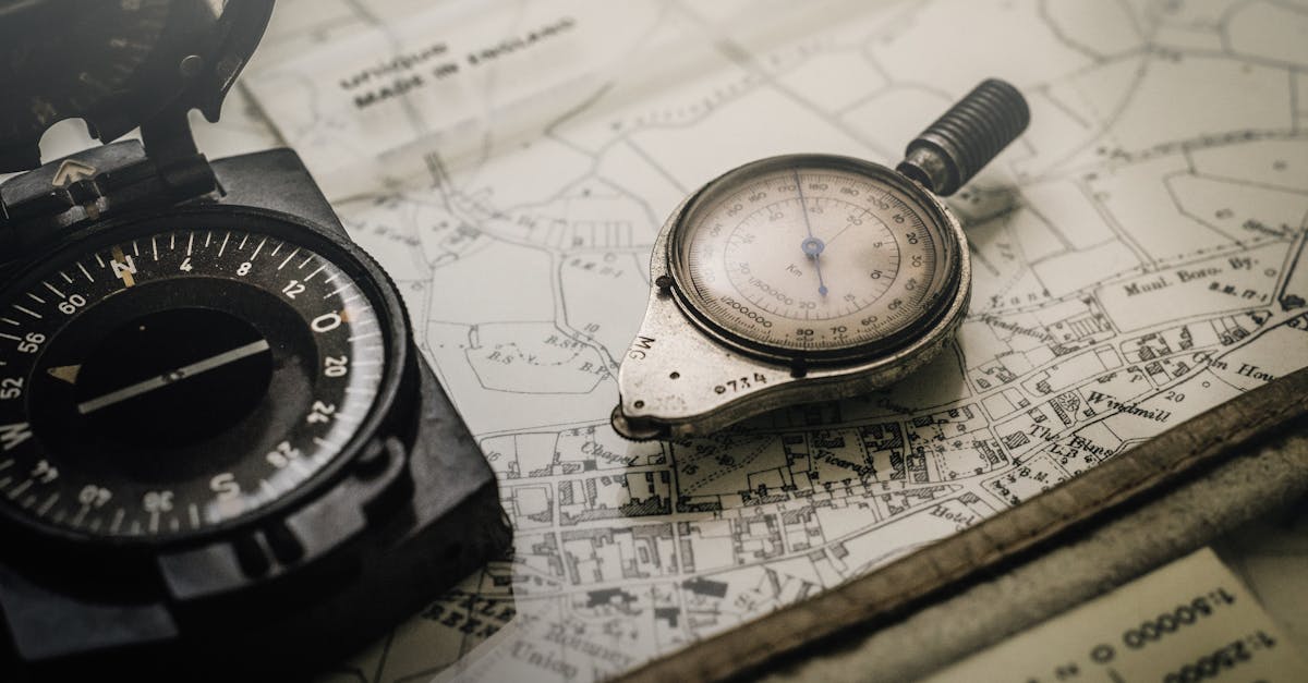 Shallow Focus Photography of Black and Silver Compasses on Top of Map