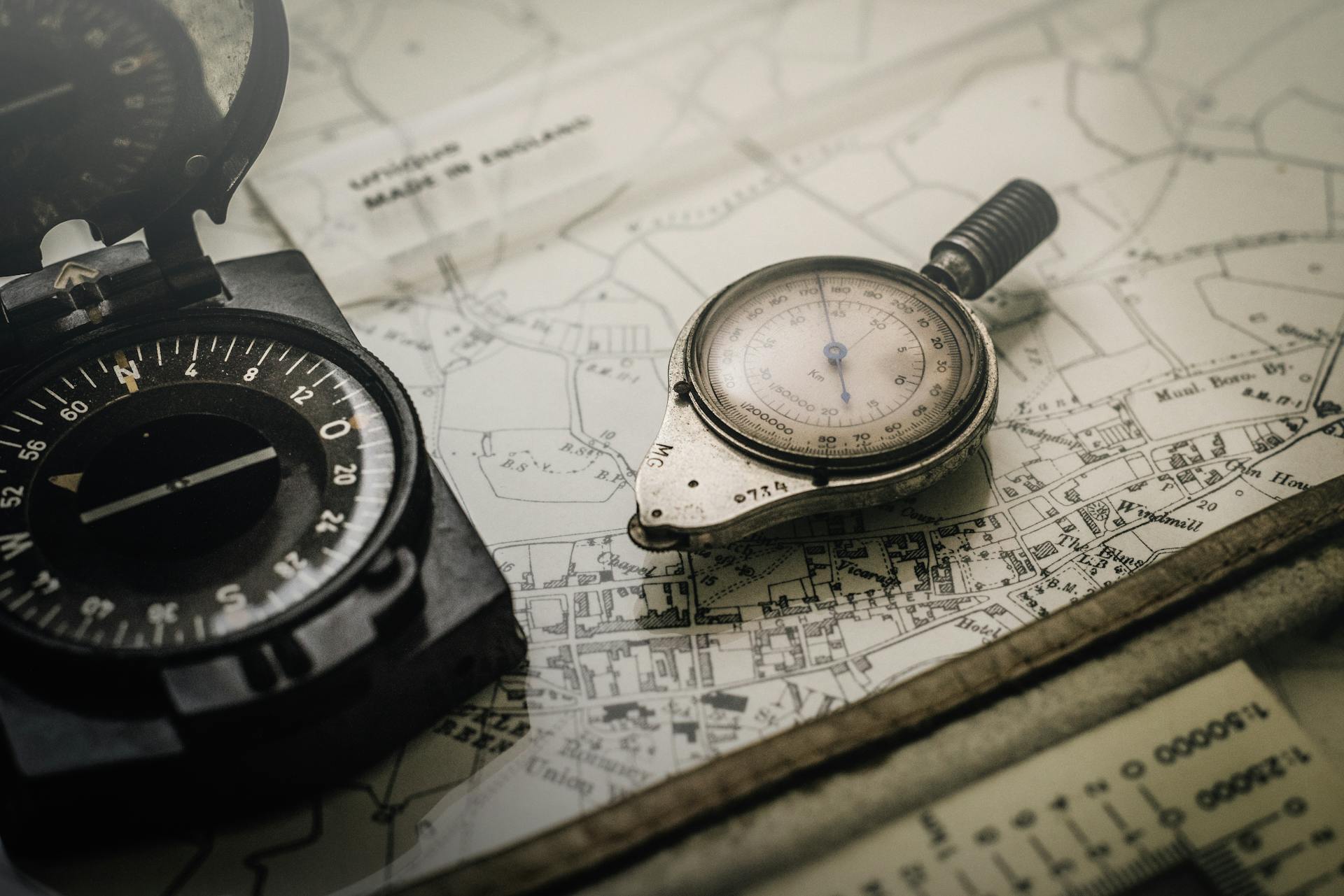 Shallow Focus Photography of Black and Silver Compasses on Top of Map