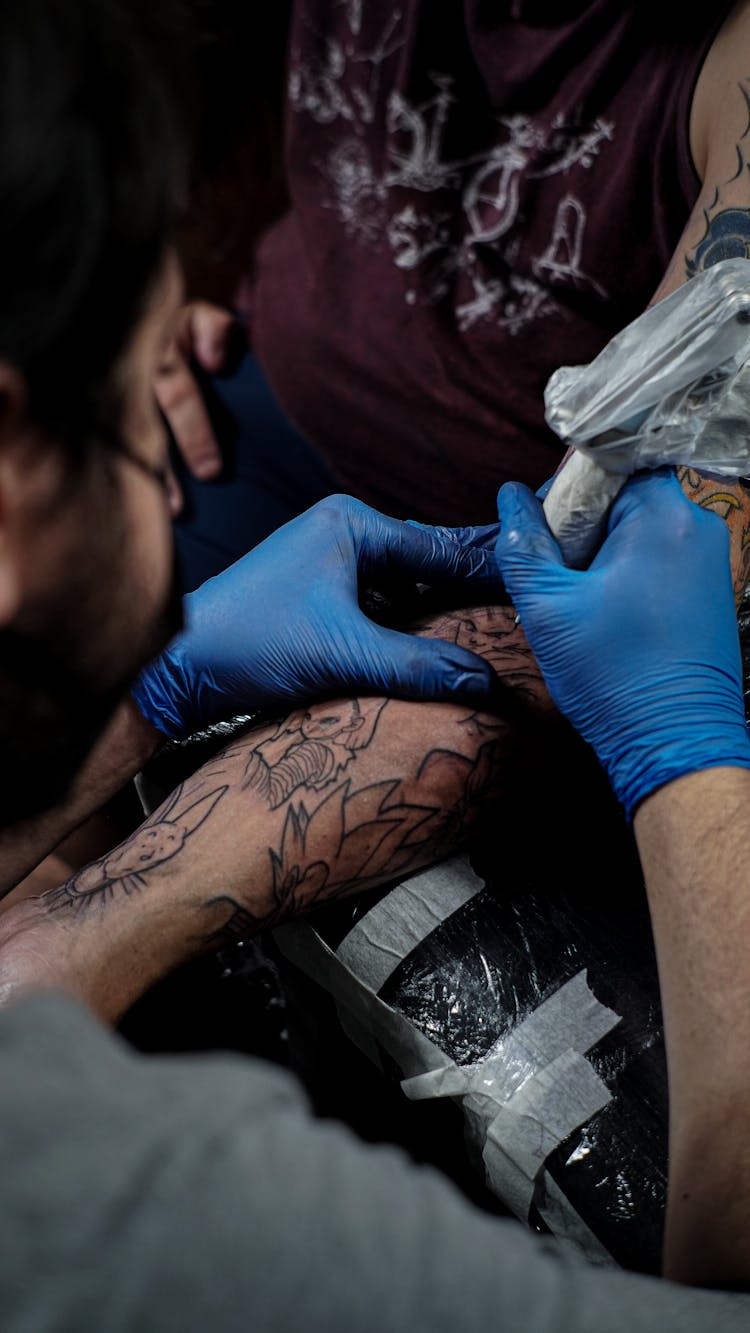 An Artist Tattooing An Arm 