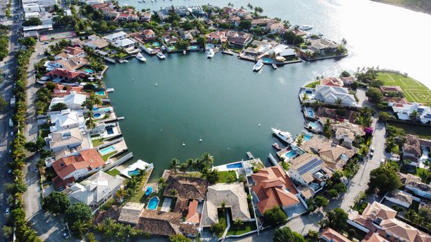 A stunning aerial view of a circular residential area with luxurious homes surrounding a serene lake.