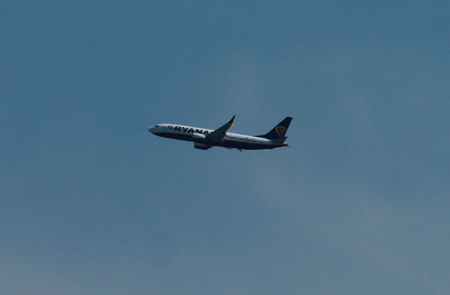 A commercial airplane flies high above the clear blue skies near Pisa, Italy. — arriving in Pisa