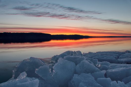 Stunning sunset view over icy Lake Pepin in Lake City, MN, reflecting vibrant colors.