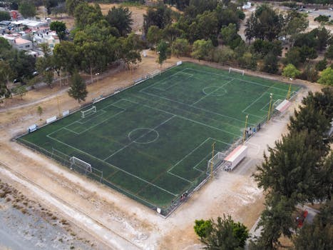Drone shot of a soccer field surrounded by trees in Zapopan, Jalisco, Mexico.