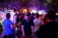 夜晚的户外人头攒动，人们在节日氛围中欣赏着活力四射的展览灯光