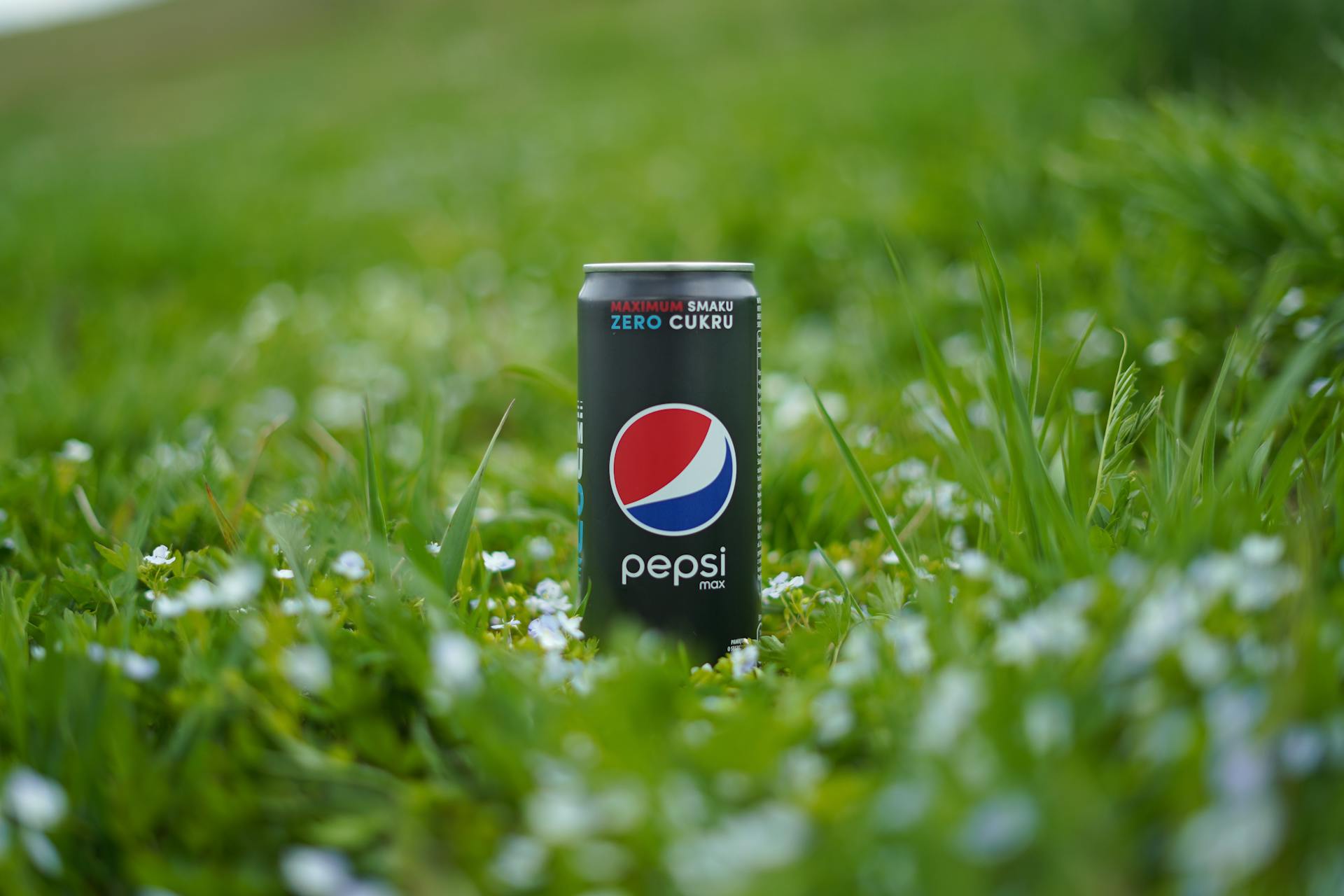 Close-Up Shot of a Pepsi Can on Green Grass