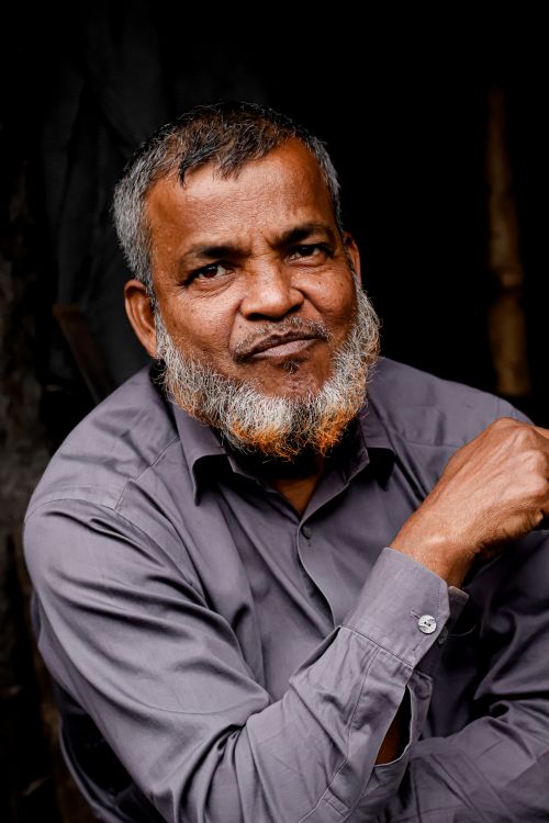 Free Close-up portrait of a mature South Asian man with a striking colored beard, exuding confidence. Stock Photo