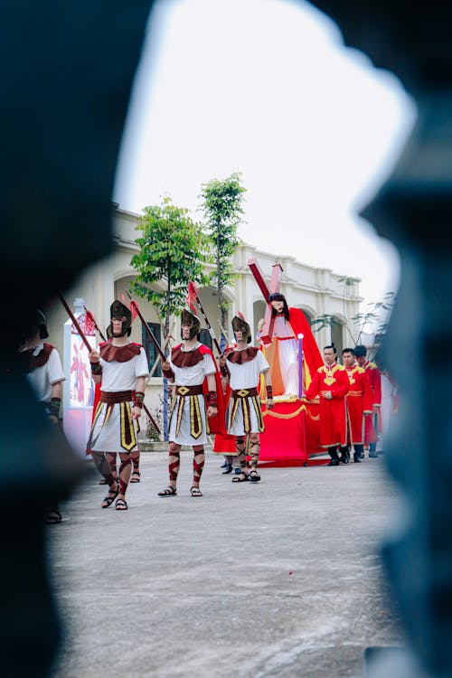 Photo of a Parade of Men Dressed Up as Roman Soldiers Reenacting the Last Journey of Jesus Christ to Mount Golgotha in a Parade
