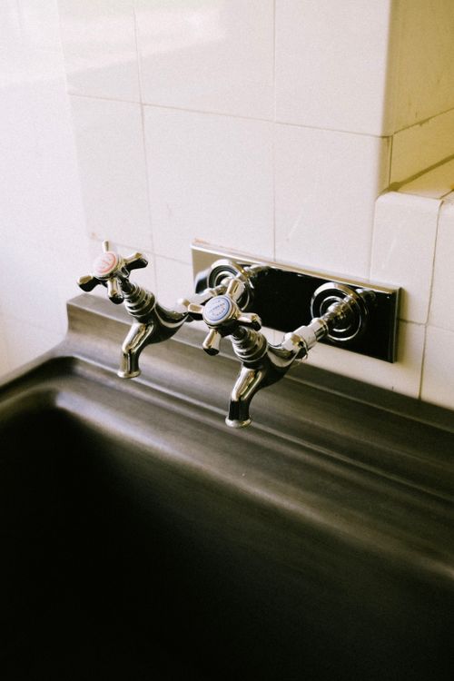 Free Stylish vintage chrome faucets over a sleek black sink, highlighting bathroom luxury. Stock Photo