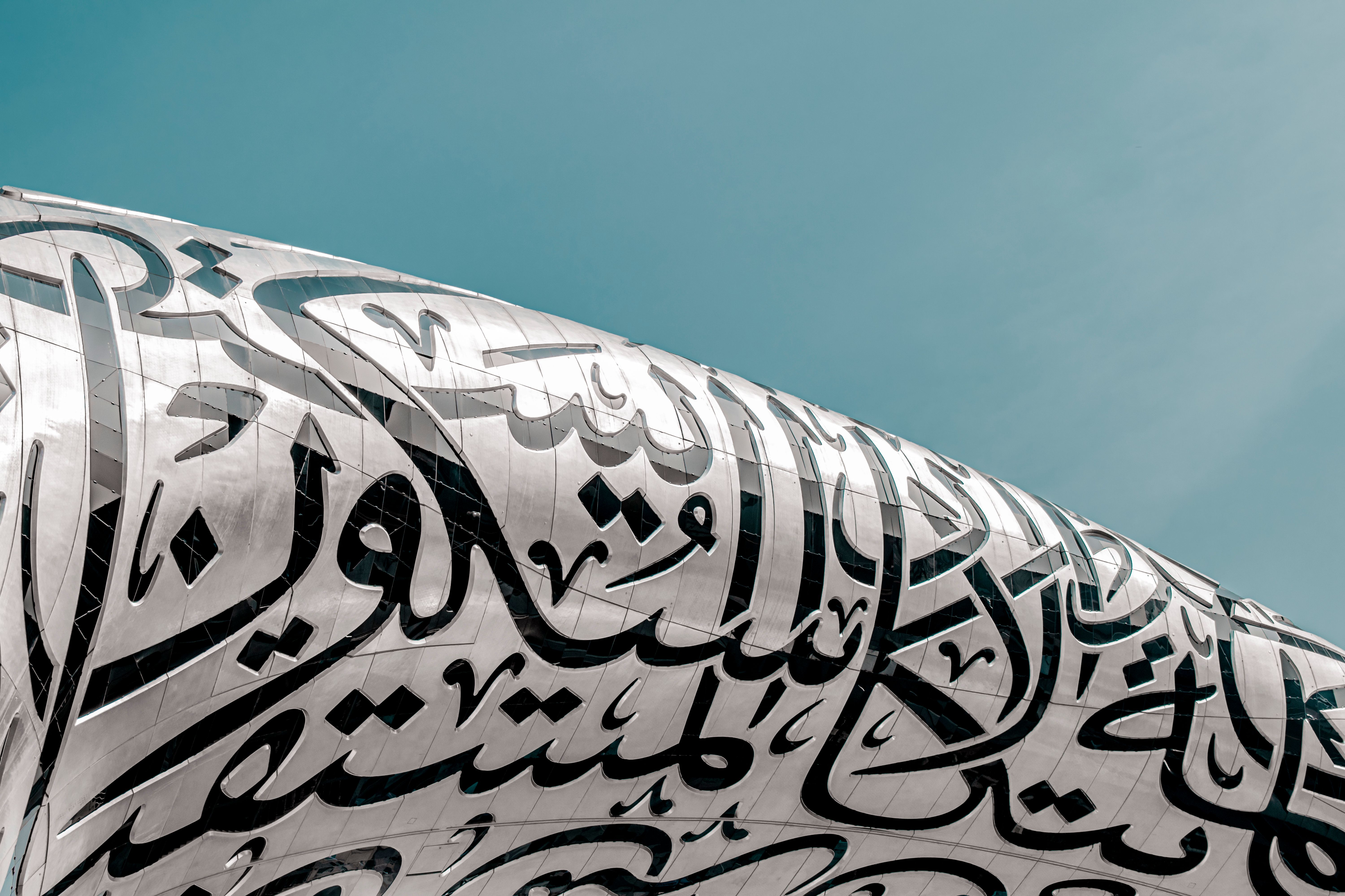Close-up of Museum of the Future facade in Dubai featuring intricate Arabic calligraphy against a bl