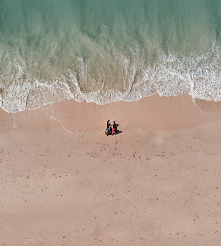 Couple Lying On The Sandy Beach