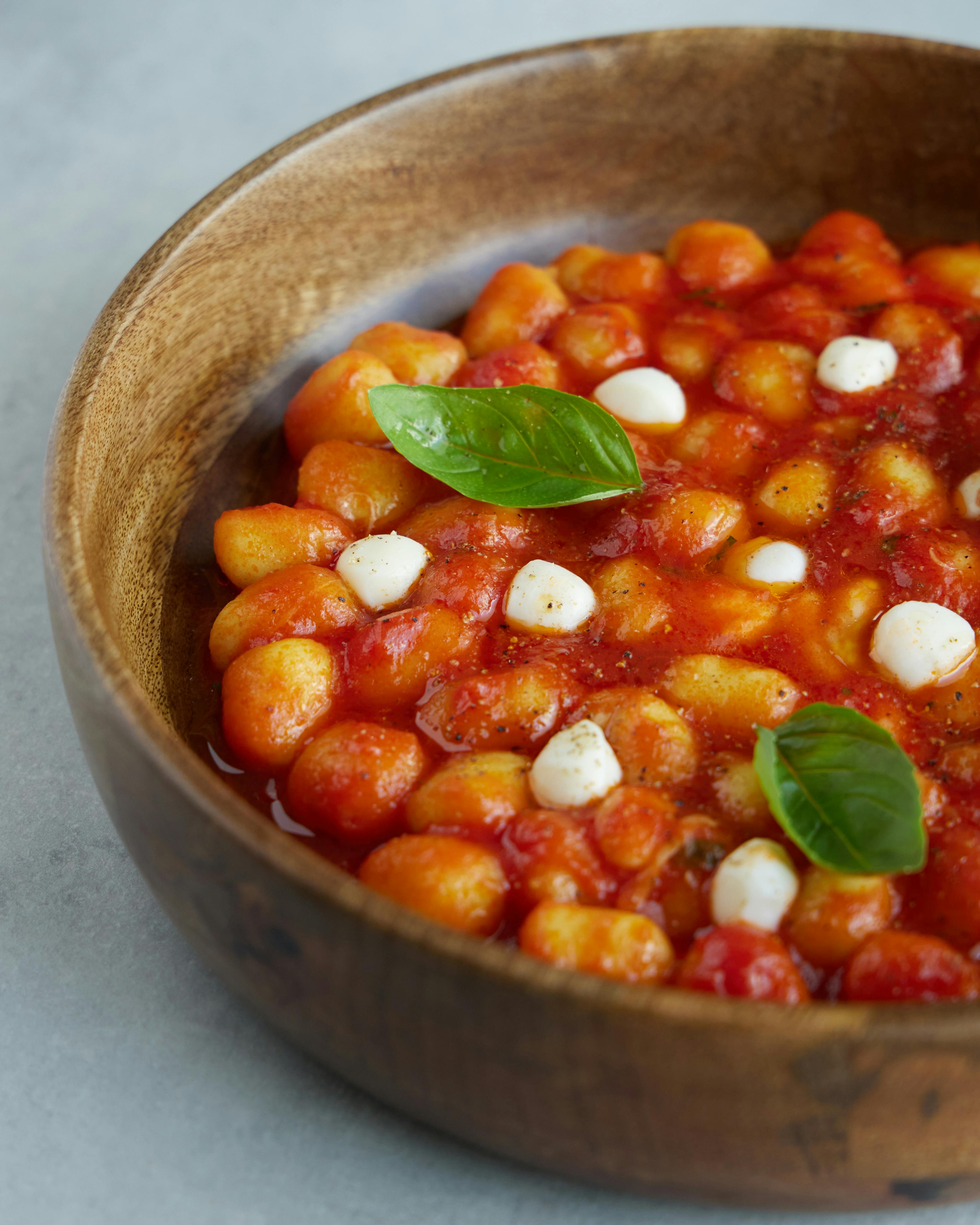 Delicious Italian gnocchi in tomato sauce with mozzarella and basil, perfect for food photography.