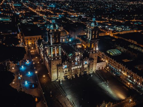 Free Stunning aerial nighttime view of Puebla Cathedral illuminated amidst city lights in Puebla, Mexico. Stock Photo