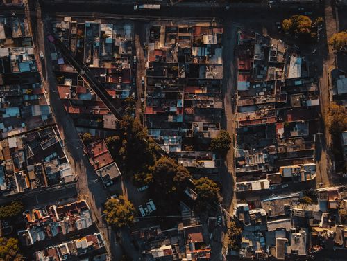 Free Drone shot capturing a dense residential area with streets and trees. Stock Photo