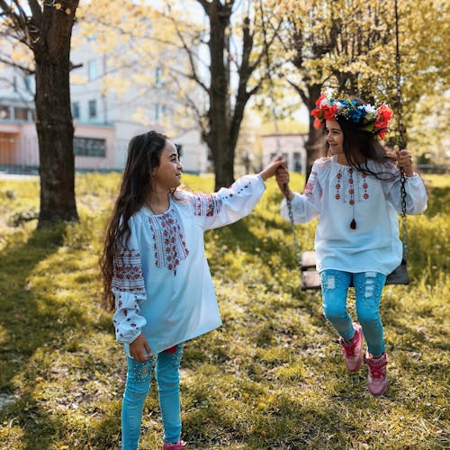 Free Little Girls Playing Outside on a Swing  Stock Photo