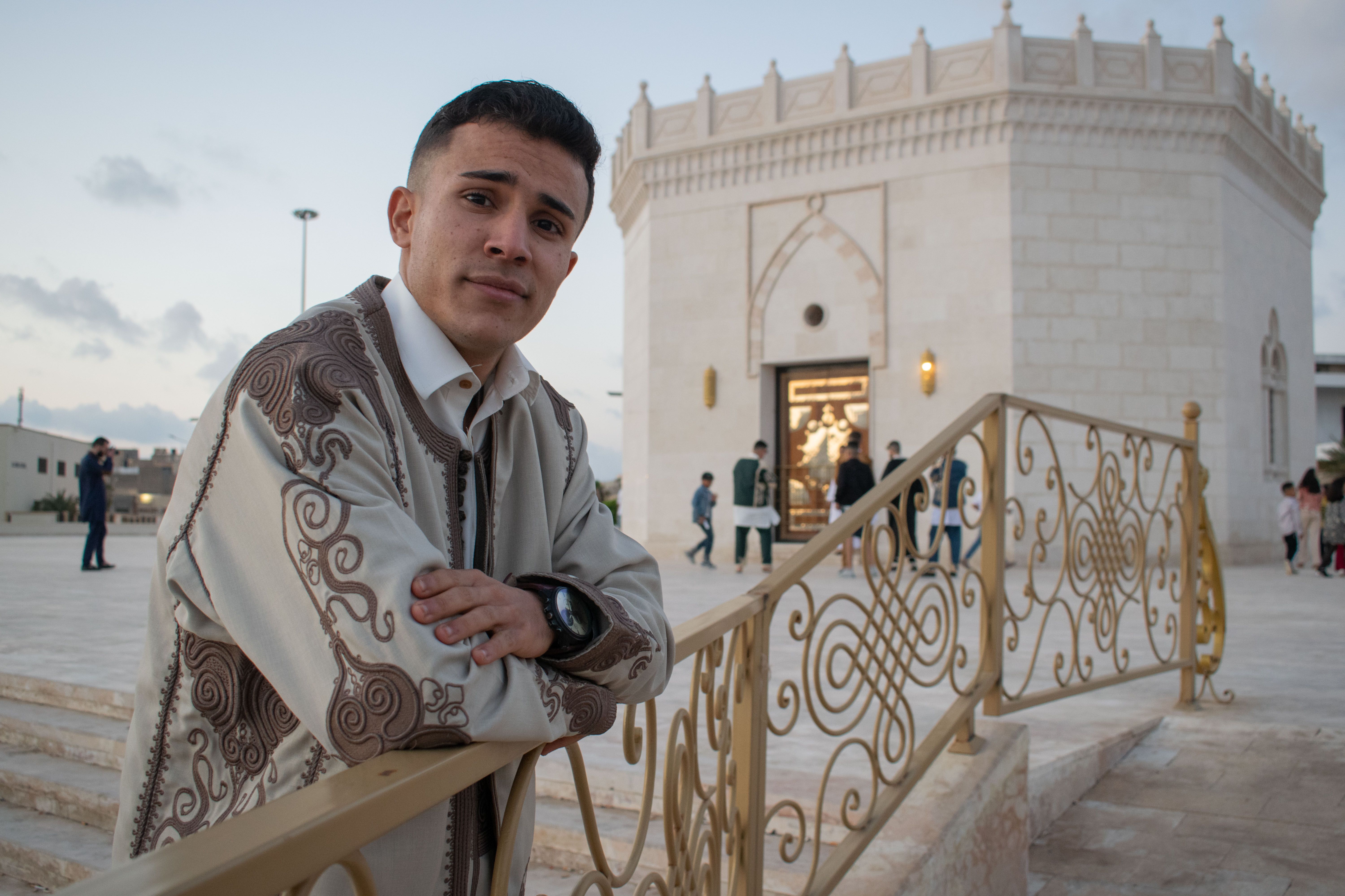 Close-Up Shot of a Man in Traditional Clothes Leaning on Metal Railing